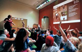 Operation Lifesaver volunteer in a classroom with children showing a rail safety slide